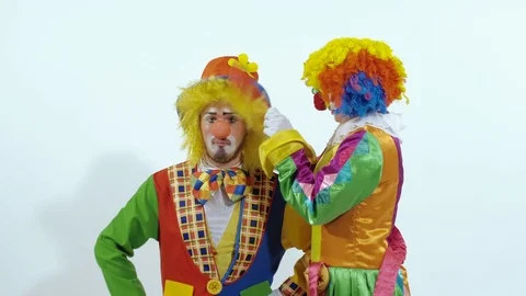 Circus clown trying to comb the other is hair and finally taking big scissors Stock-Footage 70285297