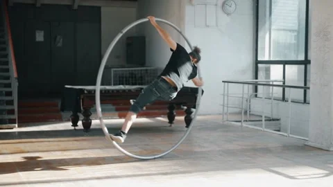 Circus performer Rotates on the Syrah wheel indoors on the parquet Stock-Footage 168373822