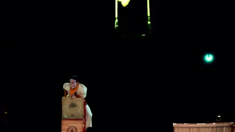 Circus tightrope walker holding on to two ropes while doing a show climbing up Stock Footage 227783612