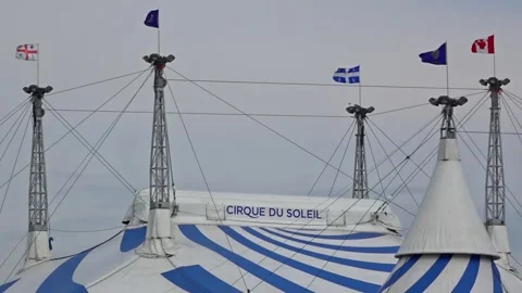 The Cirque du Soleil big top tent with flags waving from its peaks Stock Footage 339651139