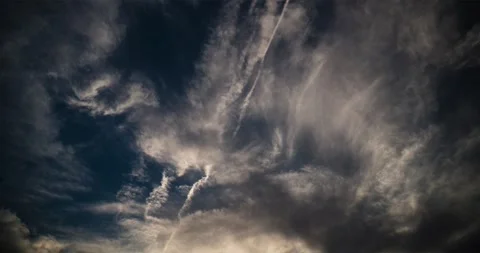 Cirrus and a cirrostratus cloudscape criss-crossed and by contrails. Stock Footage 346584347