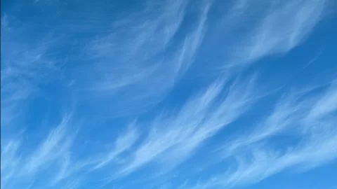 Cirrus cloud floating in clear blue sky. Wispy meteorological formations on b Foto stock