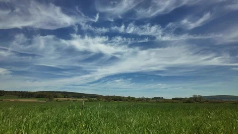 Cirrus clouds moving above a green meadow in the Altmühl Valley Stock Footage 344809943