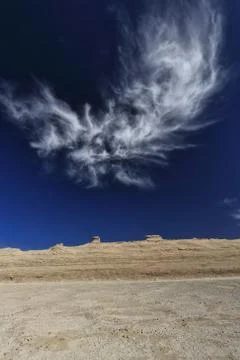 Cirrus uncinus cloud over eroded horse head-shaped yardangs. Qaidam basin-CN Stock-Fotos