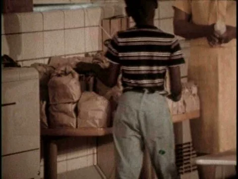 In cities, some schools distribute lunch bags in a multi-purpose room, whileƒ Vídeo Stock 75293704
