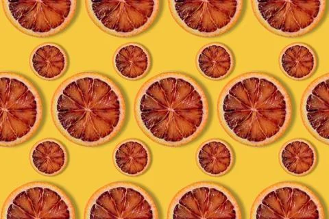 Citrus background, pattern of red orange slices on yellow background Foto stock