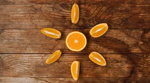 Citrus composition, orange in the shape of sun on the wooden background. Stock Photos