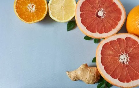 Citrus fruit and ginger root on a blue background. Vitamin C. Stock Photos