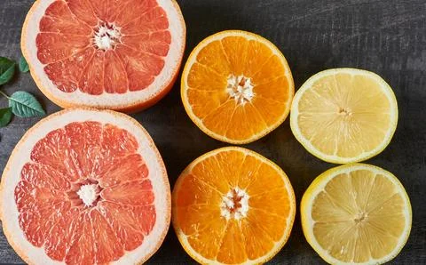 Citrus fruit halves on the table. Preparing citrus juice. Stock Photos