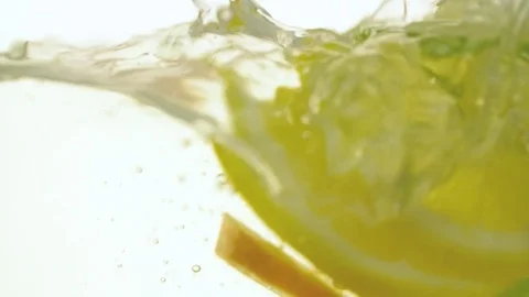 Citrus fruit slices falling to water slow motion close up video floating lime Stock Footage 83932505