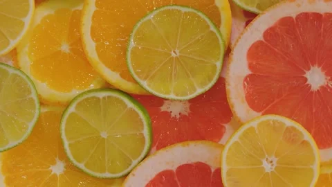 Citrus fruit slices - orange, grapefruit, lemon, lime on rotating surface Stock Footage 233844690