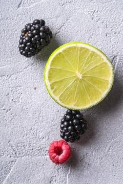 Citrus lime slice, raspberry and blackberry berries, healthy summer fruits Stock Photos
