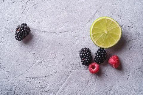 Citrus lime slice, raspberry and blackberry berries, healthy summer fruits Stock Photos