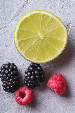 Citrus lime slice, raspberry and blackberry berries, healthy summer fruits Stock Photos