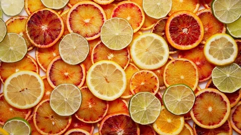Citrus Ring Medley: Background of Oranges, Lemons, and Limes Cut into Rings Stock Footage 241324671