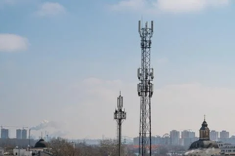 City antennas overview. Communication structures amidst city rooftops with .. Stock Photos