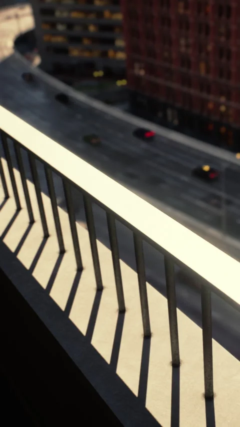 City balcony view with sunlight casting shadows on the railing Stock Footage 335694189