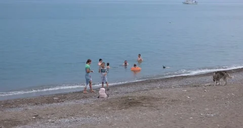 City beach on a cloudy summer day with a few vacationers Stock Footage 207012349