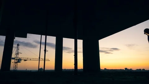 City building in progress with engineers walking along it at sunset Stock Footage 119090356