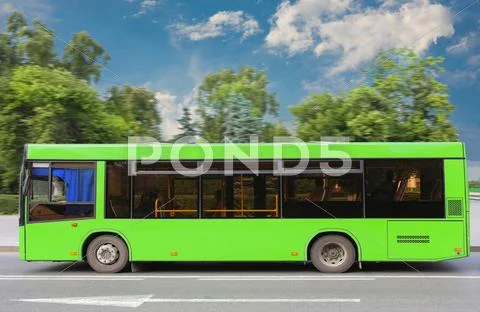 City bus moves down the street Stock Photos