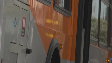 City Bus Stops At Bus Stop And Opens Doors For Passengers To Exit Video stock 206864664