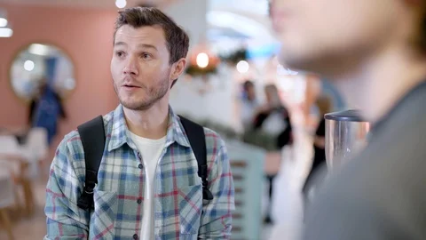 City cafe. The young man communicates with the barista, and makes an order. Stock Footage 99236573