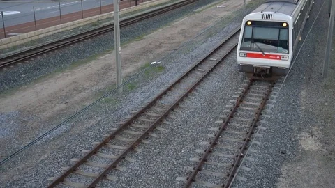 City commuter train passing under an overpass Stock Footage 93533271