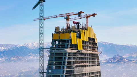 City construction site of skyscraper with cranes, with mountain background Stock Footage 322995912