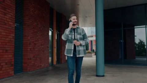 City Conversations Front View of a Smiling Young Man walking Engaging in Video stock 252354900