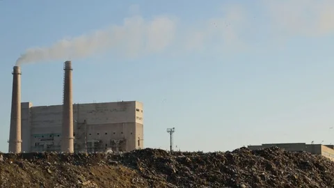 City dump. Garbage dump on factory background. Smelly smoke comes from factory Stock Footage 99053235