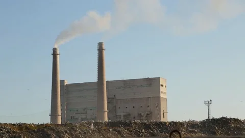 City dump. Garbage dump on factory background. Smelly smoke comes from factory Stock Footage 99053306