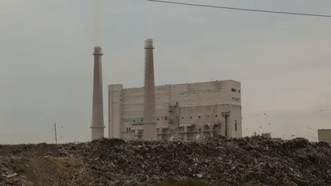 City dump. Garbage dump on factory background. Smelly smoke comes from factory Stock Footage 99053743