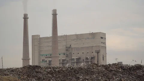 City dump. Garbage dump on factory background. Smelly smoke comes from factory Stock Footage 99054015