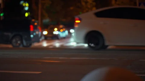 City intersection bustling with evening traffic under streetlights Stock Footage 323730132