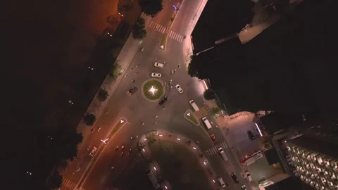City intersection at night showing traffic flow and bright streetlights Stock Footage 308246509