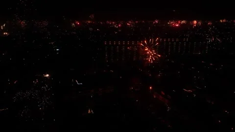 City lights create a glittering tapestry below, dazzling fireworks above. Stock Footage 260927658