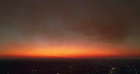 City Lights Flicker Beneath a Blanket of Smoke at Dusk Stock Footage 335474850