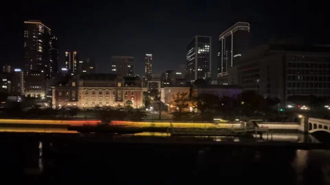 City lights reflecting on the river in front of Osaka's skyline Video stock 339689014