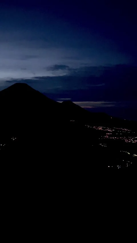City Lights on the Slopes of Mount Sindoro During the Blue Hour Before Sunrise 스톡 동영상 340150931