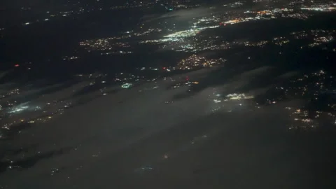 City lights through drifting clouds at night from an airplane Stock-Footage 348050866