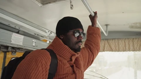 City man rides transit thoughtfully. Contemplative traveler on winter city bus Vidéo 333175975
