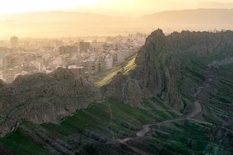 City of Qom, Iran, in a dramatic sunset viewed from the hill nearby. Steep rock Stock Photos