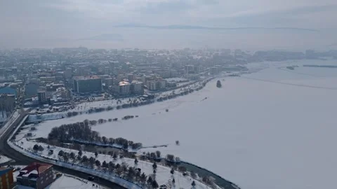 A city with a river running through it and snow on the ground Stock Footage 328244403