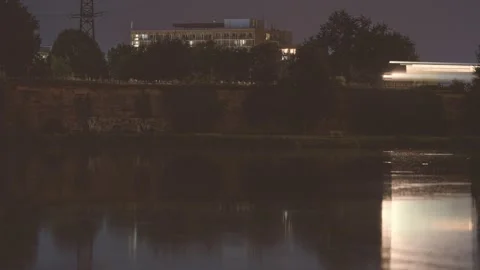 A city scene at night captures a passing train’s motion blur with Stock Footage 286867085