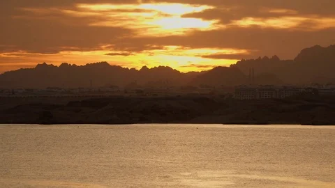City by the sea and mountains against the sky at sunset Stock Footage