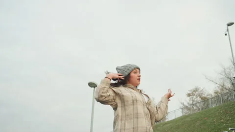 City skyline dance performance. Dancer performs expressively against cityscape Stock Footage 345154347