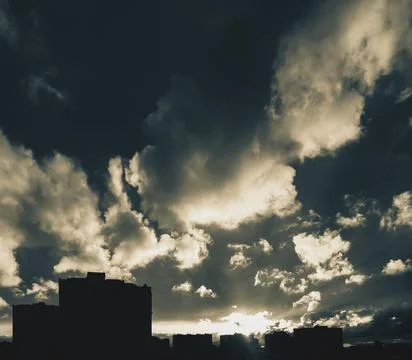 City skyline with dramatic cloudy sky at sunset Stock-Fotos