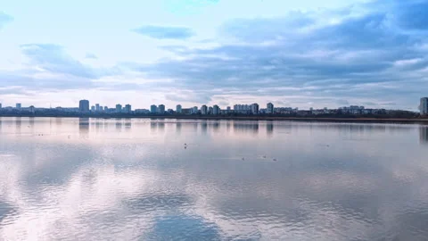 City skyline reflected on calm water during the day with clouds overhead. City Stock Footage 343796192