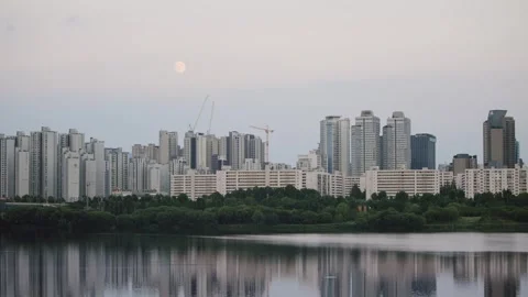 City skyline at sunset reflecting over calm river in Seoul Stock Footage 314072745