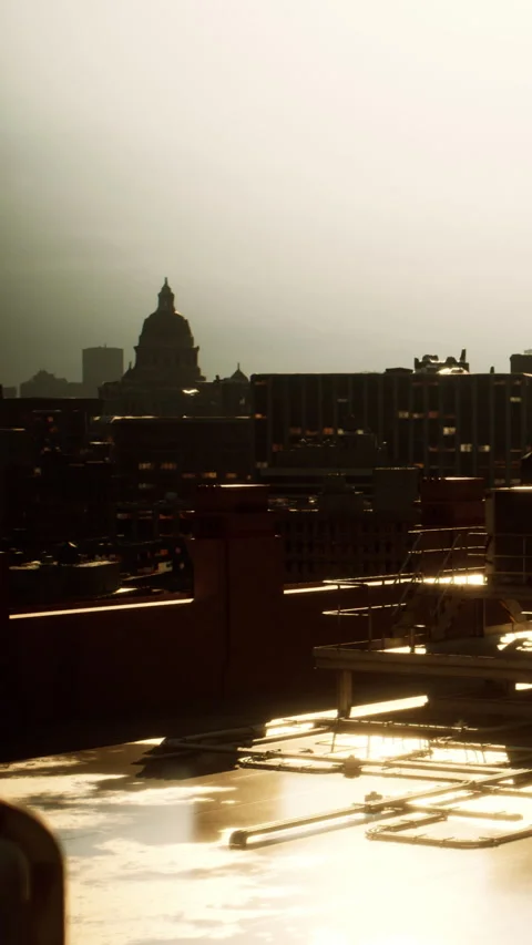 City skyline at sunset viewed from rooftop with reflections on surface Stock Footage 337933592